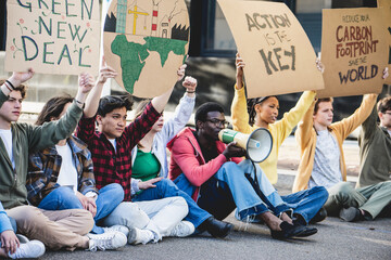 Group of young activists against land exploitation and climate change exercise the right to protest and make a sit in - obrazy, fototapety, plakaty
