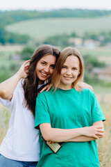 Obraz premium beautiful happy girlfriends.happy sisters.girls are resting in nature.Women are hugging.Girls are laughing.Two girls girlfriends in nature.Beautiful women.Friendship and love.Friendly support.