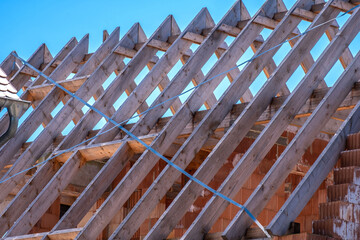 Obraz premium Rohbau eines Wohnhauses mit roten Hohllochziegelsteinen und einem Dachstuhl aus Holz