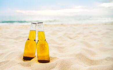 Bottles of Beer on the sandy beach with sea ocean background. Party, Friendship, Beer Concept.