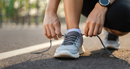 closeup of young woman runner tying her shoelaces. healthy and fitness concept.