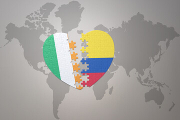 puzzle heart with the national flag of colombia and ireland on a world map background.Concept.