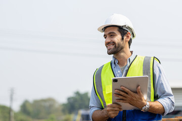 Heavy-duty industrial engineers stand in a pipeline manufacturing facility using digital tablet...