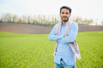 Portrait of young Indian Farmer wearing formal dress in green paddy field.