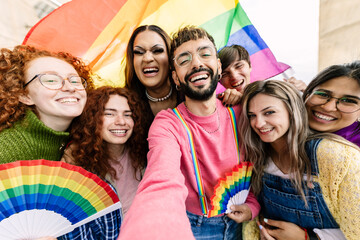 Young group of friends with rainbow flags celebrating gay pride day festival together. LGBT community people concept.