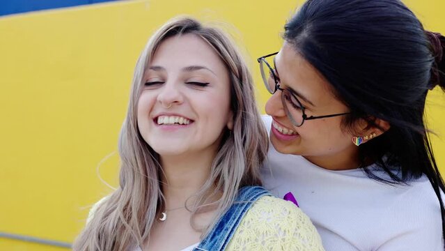 Young teen girls kissing outdoors. Lesbian couple embracing together showing love. Gay pride festival day concept.