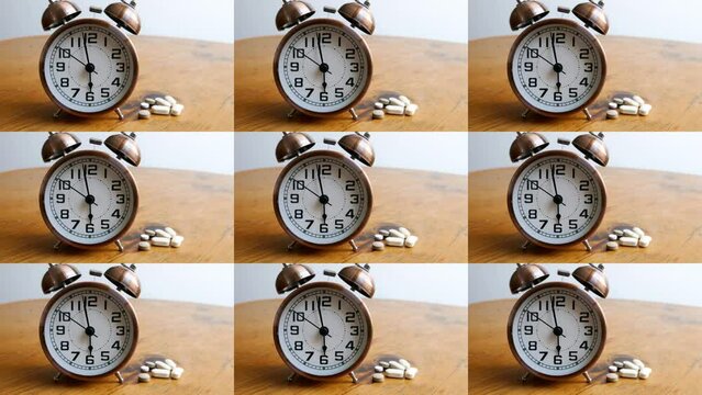 ( alarm clocks and pills on bedside table