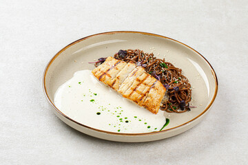 Portion of halibut fillet with soba noodles and creamy sauce