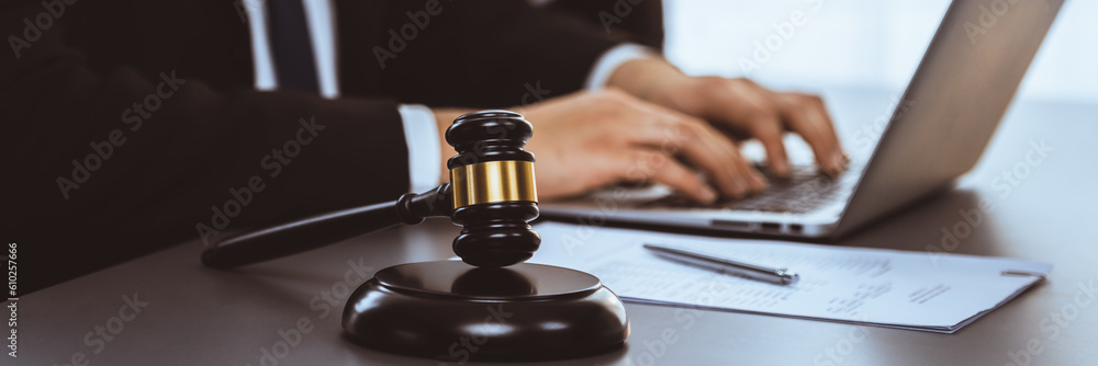 Wall mural Focus gavel hammer for righteous and equality judgment with blur background of lawyer colleagues or legal team working with laptop, drafting legal documents for litigation at law firm. Equilibrium