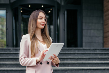 female financial analyst holding the tablet and looking away