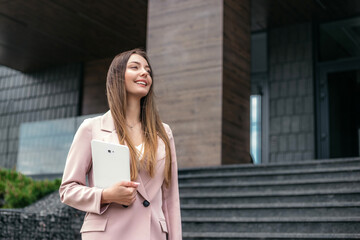 business woman financial analyst holding the tablet and looking away