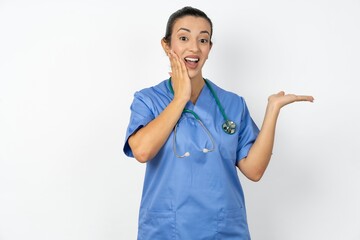 Crazy Beautiful doctor woman standing over white studio background advising discount prices hold...