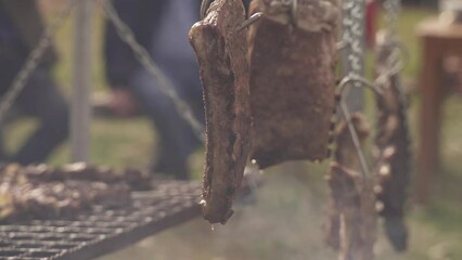 Fresh ribs hanging and degreasing during barbecue outdoor event,close up
