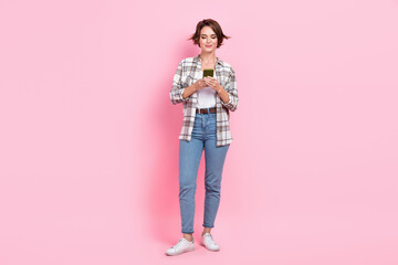 Obraz na płótnie Canvas Full body portrait of pretty lovely lady hold use smart phone typing blog post isolated on pink color background