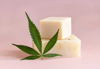 Craft soap bar near green cannabis leaves on pink close up. Cosmetic Mockup