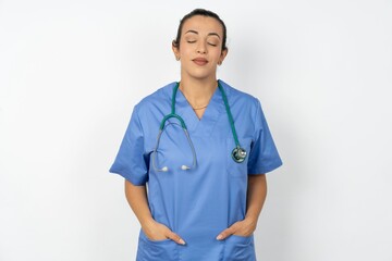 Beautiful doctor woman standing over white studio background nice-looking sweet charming cute attractive lovely winsome sweet peaceful closed eyes