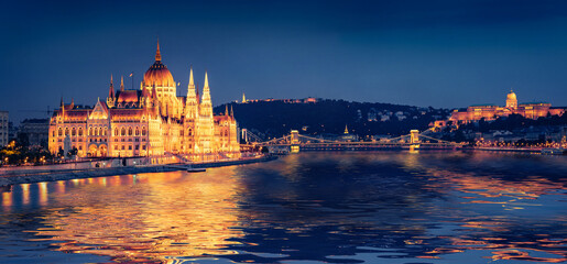 Parliament building and Chain Bridge reflected in the xcalm waters of Danube river. Panoramic...