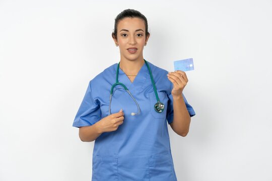 Photo of happy cheerful smiling positive Beautiful doctor woman standing over white studio background recommend credit card