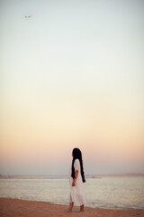 Fototapeta premium girl walking on the beach at sunset