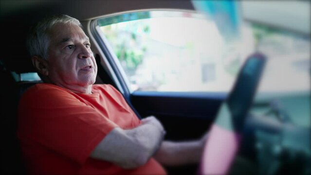 Older man putting seatbelt while driving. Senior driver fastening security device while holding vehicle steering wheel, Safety Conscious