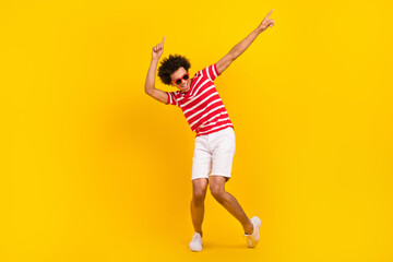 Fototapeta na wymiar Full size photo of funky guy dance active youth moves wear summer shirt pants shoes sun specs isolated yellow color background