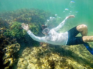 Man diving underwater with mask and snorkel at Cupe beach, PE