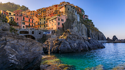 Fototapeta na wymiar Traditional colorful houses above the Mediterranean Sea in the romantic old town of Manarola in Cinque Terre, Italy in a morning light