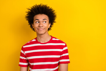 Photo of wondering funny youngster guy good mood look side empty space wear striped shirt isolated...