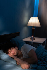 Good sleep concept. Handsome young man sleeping in comfortable bed alone at home, enjoying his...