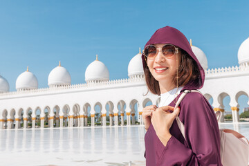 Against the backdrop of the awe-inspiring Sheikh Zayed Grand Mosque, a tourist girl in Abaya revels...