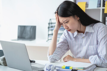 Concept Burnout Syndrome. Asian business Woman feels uncomfortable working. Which is caused by...