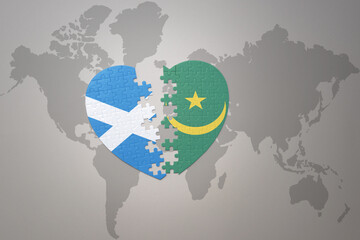 puzzle heart with the national flag of mauritania and scotland on a world map background.Concept.
