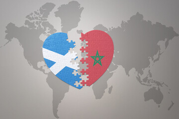 puzzle heart with the national flag of morocco and scotland on a world map background.Concept.