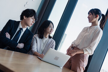 オフィスで仲良く話す若いビジネスパーソン