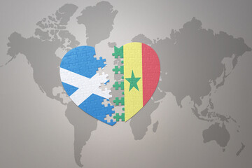 puzzle heart with the national flag of senegal and scotland on a world map background.Concept.