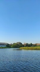 Fototapeta premium Small island in the middle of lake in the city park during sunny day