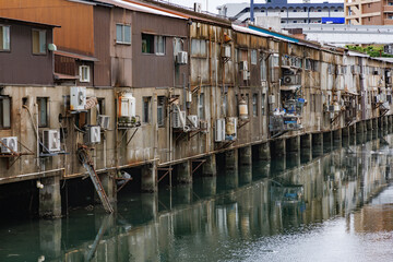 川沿いに建つ古びた建物　 旦過市場（たんがいちば）