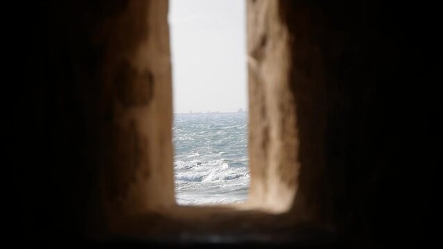 A View of the Sea Through a Narrow Opening in the Stone Wall