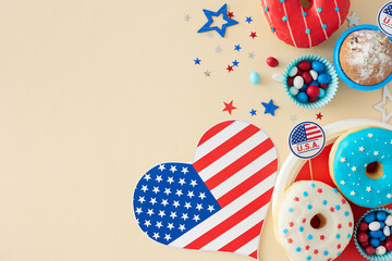 Obraz premium The concept of a sweet-centric festivity on July 4th. Top view flat lay of american flag in the shape of a heart, patriotic sweets, confetti on pastel beige background with space for ad or text