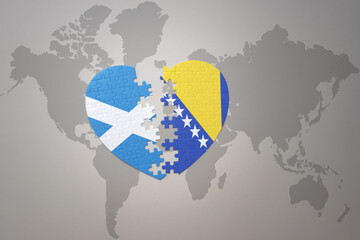 puzzle heart with the national flag of bosnia and herzegovina and scotland on a world map background.Concept.