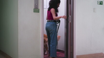 Woman opening elevator door going for a walk with her Dog on a leash. Daily routine of person domestic lifestyle entering elevator with Pet © Marco