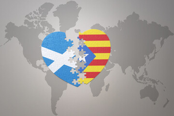 puzzle heart with the national flag of catalonia and scotland on a world map background.Concept.