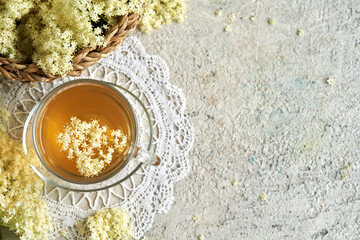 Obraz na płótnie Canvas Herbal tea with fresh elderberry flowers on textured background with copy space