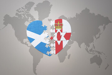 puzzle heart with the national flag of northern ireland and scotland on a world map background.Concept.