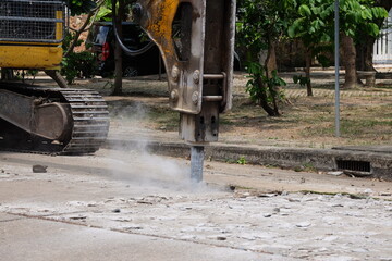 Road drilling vehicle, backhoe, yellow, attached to the drilling head, the Yak head, working