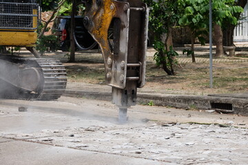 Road drilling vehicle, backhoe, yellow, attached to the drilling head, the Yak head, working