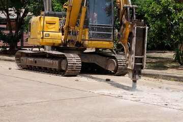 Road drilling vehicle, backhoe, yellow, attached to the drilling head, the Yak head, working