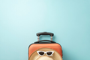 Beach holiday concept. Top view of an orange suitcase, beach accessories, sunglasses, and sunhat,...