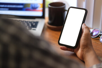 Close up over shoulder businessman using mobile phone at office desk..