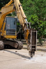Road drilling vehicle, backhoe, yellow, attached to the drilling head, the Yak head, working